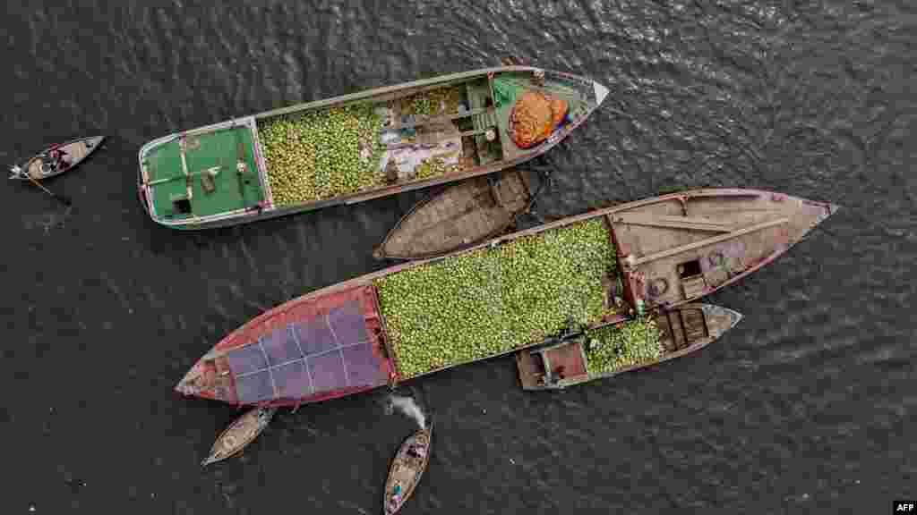 انتقال تربوزها از کشتی کوچک باربری به قایق&zwnj;ها برای فروش در مارکیت میوه فروشی در سواحل دریای بریگنگا واقع در شهر داکه، پایتخت بنگله&zwnj;دیش &nbsp;
