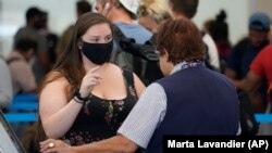 A passenger is assisted by an American Airlines employee at Fort Lauderdale-Hollywood International Airport, Tuesday, April 19, 2022