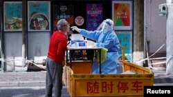 2022年4月22日，一名醫護工作人員在上海街頭為居民進行核酸檢測。