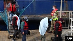 FILE: Members of the British military assist UK Border Force officers as migrants disembark at the port of Dover after being picked up crossing the English Channel from France on April 14, 2022. 