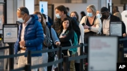 乘客们在华盛顿城外的里根国家机场排队等候接受安检。(2022年4月19日)