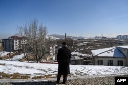 FILE - A man stands on the heights of the city to look at the view, in Erzurum, east Turkey, March 5, 2021. More and more men in the eastern regions of the country, struggling to make ends meet, are paying smugglers to take them to the United States.