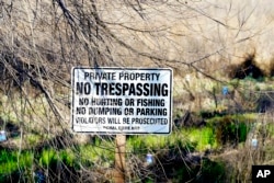 A "No Trespassing" sign stands on the Dos Rios Ranch Preserve, California's largest single floodplain restoration project in Modesto, Calif., on Wednesday, Feb. 16, 2022. (AP Photo/Rich Pedroncelli)