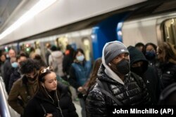 Mass transit riders wear masks as they commute in the financial district of lower Manhattan, Tuesday, April 19, 2022, in New York.