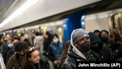 Mass transit riders wear masks as they commute in the financial district of lower Manhattan, Tuesday, April 19, 2022, in New York. (AP Photo/John Minchillo)