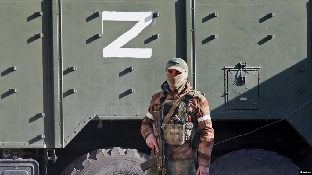 在被俄罗斯围攻的乌克兰港城马里乌波尔,一名亲俄部队成员站在一辆标有Z字符的军车旁.(2020年4月20日)(photo:VOA)