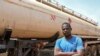 FILE - A driver poses next to his tanker truck at the border town of Garoua-Boulai, Cameroon, Jan. 8, 2021.