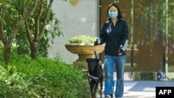 This photo taken on April 16, 2022 shows a resident walking her dog in a residential housing compound during the Covid-19 lockdown in Shanghai.