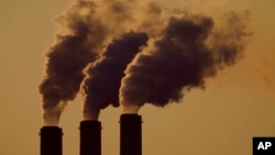 FILE - Emissions rise from the smokestacks at the Jeffrey Energy Center coal power plant as the suns sets, near Emmett, Kan., Sept. 18, 2021.