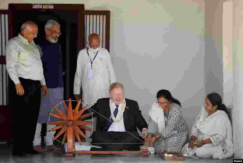 Britain&#39;s Prime Minister Boris Johnson spins cotton on a wheel during his visit to the Sabarmati&nbsp;Ashram&nbsp;in Ahmedabad, India.