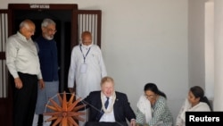 Perdana Menteri Inggris Boris Johnson memintal kapas saat berkunjung ke Ashram Gandhi di Ahmedabad, India, 21 April 2022. 