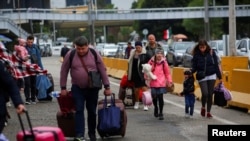 러시아의 침공으로 모국을 떠난 우크라이나인들이 미국 입국을 위해 멕시코 티후아나의 산 이시드로 국경검문소로 걸어가고 있다. (자료사진)