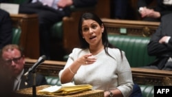 A handout photograph released by the UK Parliament shows Britain's Home Secretary Priti Patel gesturing as she gives a statement concerning the plan to send migrants and asylum seekers who cross the Channel to Rwanda.