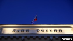 FILE - A Russian state flag flies over the Central Bank headquarters in Moscow, March 29, 2021. The sign reads "Bank of Russia". 