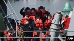 FILE - Migrants prepare to disembark from a UK Border Force boat at the port of Dover, having been picked up crossing the English Channel from France on April 15, 2022, at Dover, England.