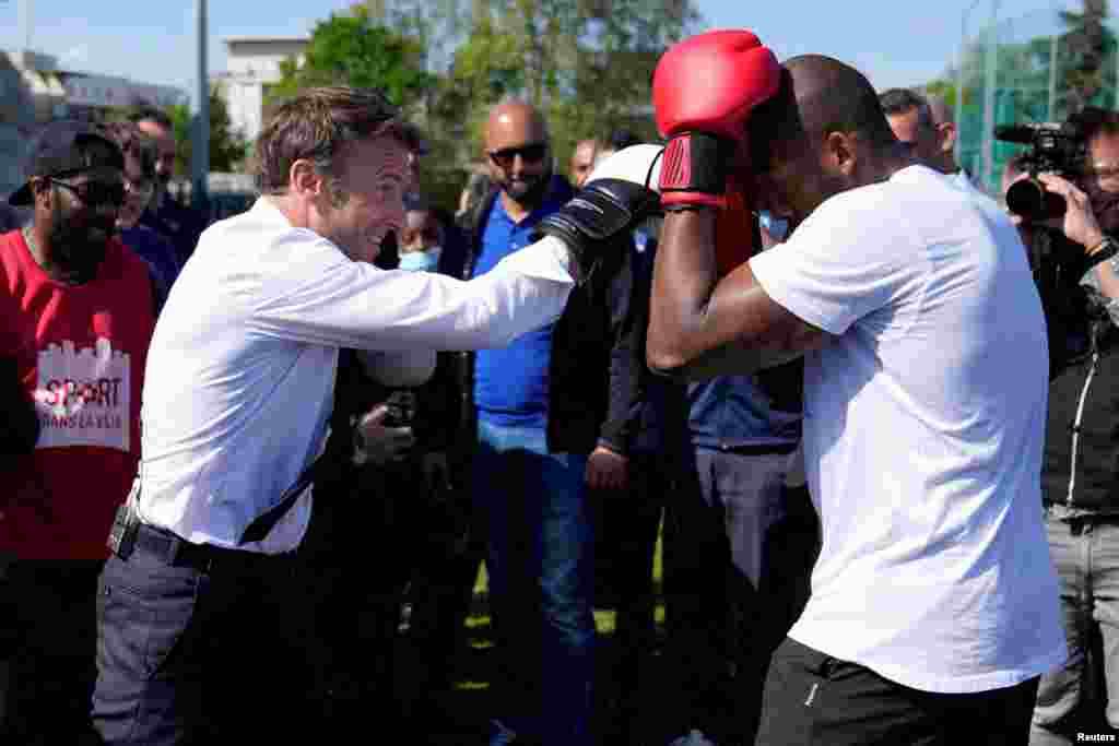 French President and La Republique en Marche (LREM) party candidate for re-election Emmanuel Macron trains with amateur boxer Jean-Denis Nzaramba, 23, in the Auguste Delaune stadium in Saint-Denis, a northern suburb of Paris.