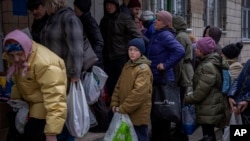 Sergei, 11, waits his turn to receive donated food during an aid humanitarian distribution in Bucha, in the outskirts of Kyiv. April 19, 2022. 