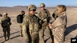 FILE: Army Secretary Christine Wormuth, right, talks with Army Colonel Ian Palmer, commander of the 2nd Brigade, 1st Cavalry Division, at the National Training Center, April 12, 2022.