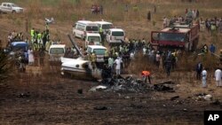 FILE - People gather at the scene of a military plane crash in Bassa, near Abuja, Nigeria, Feb. 21, 2021. The crash killed all seven people on board, said officials. 