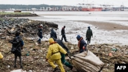 Volunteers clean up massive debris at the Durban harbor following heavy rains, mudslides and winds in Durban, South Africa, April 16, 2022.