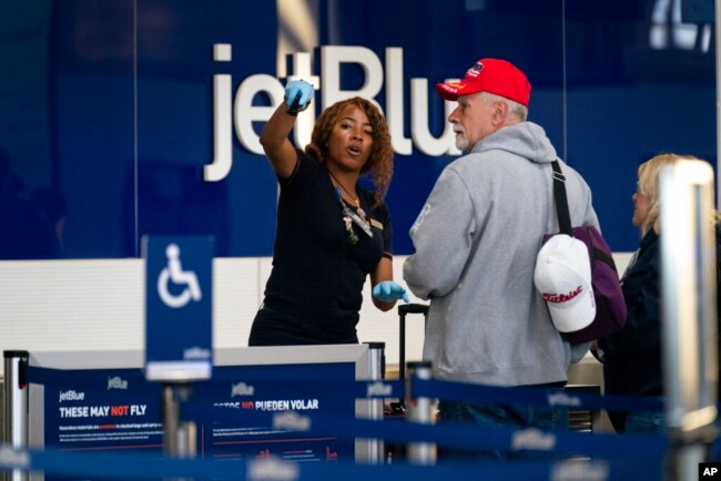 Passengers check in at the terminal at Ronald Reagan Washington National Airport, in Arlington, Va., April 19, 2022, after a federal judge's ruling to strike down a national mask mandate.