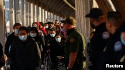 FILE - Migrants expelled from the U.S. and sent back to Mexico under Title 42 walk toward Mexico at the Paso del Norte International border bridge on April 1, 2022. U.S. authorities say they stopped migrants more than 234,000 times in April 2022.