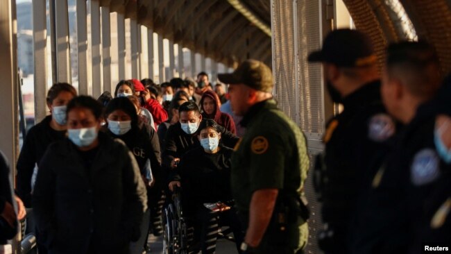 FILE - Migrants expelled from the U.S. and sent back to Mexico under Title 42 walk toward Mexico at the Paso del Norte International border bridge on April 1, 2022. U.S. authorities say they stopped migrants more than 234,000 times in April 2022.