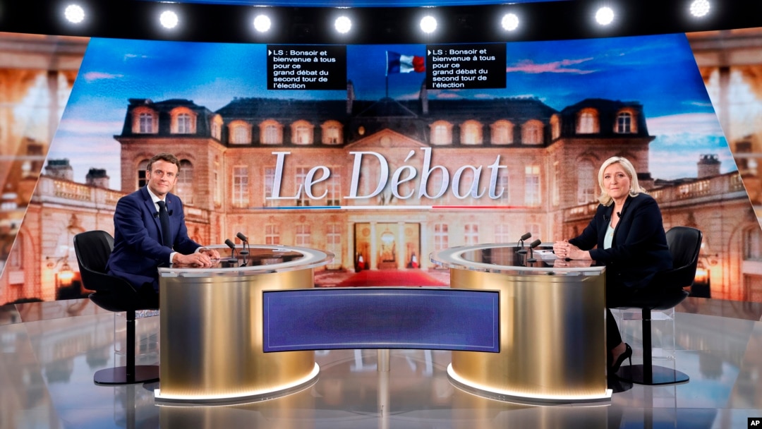 Centristički kandidat i aktuelni predsednik Francuske Emanuel Makron i kandidatkinja desnice Marin le Pen poziraju pred početak TV debate, u Parizu, 20. aprila 2022.