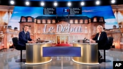 Centristički kandidat i aktuelni predsednik Francuske Emanuel Makron i kandidatkinja desnice Marin le Pen poziraju pred početak TV debate, u Parizu, 20. aprila 2022.