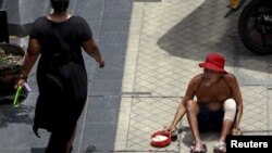 A man begs for money in central Bangkok, Thailand, May 22, 2015. When Thailand's army seized power in a bloodless coup, much of the business establishment quietly cheered them on. A year on, the captains of Thai industry remain firmly behind the junta, despite a lackluster econom