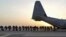 FILE - Marines and sailors with Marine Expeditionary Brigade – Afghanistan load onto a KC-130 aircraft on the Camp Bastion flightline, Oct. 27, 2014. 