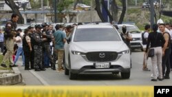 Agentes de la Policía Nacional rodean el auto en el que se desplazaba el fiscal César Suárez en el momento e ser asesinado, en Guayaquil, Ecuador, el 17 de enero de 2024.