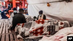 Immigrants rest aboard the Ocean Viking during its navigation in the Mediterranean Sea, April 30, 2021. SOS Mediterranee said May 1, 2021, the Ocean Viking was sailing toward a Sicilian port with 236 migrants rescued days earlier in the Mediterranean.