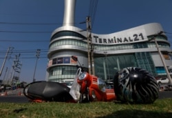 A motorcycle and helmet that belong to a victim lie in front of the Terminal 21 shopping mall following a gun battle involving a Thai soldier on a shooting rampage, in Nakhon Ratchasima, Thailand, Feb. 9, 2020.