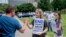 FILE - Claire Summers, 16, gets a high five as she and her sister Ella Summers, 10, protest the Southern Baptist Convention's treatment of women, outside the convention's 2018 meeting in Dallas.