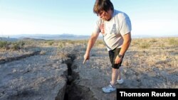 A man looks into a fissure that opened in the desert during a powerful earthquake that struck Southern California, near the city of Ridgecrest, July 5, 2019.