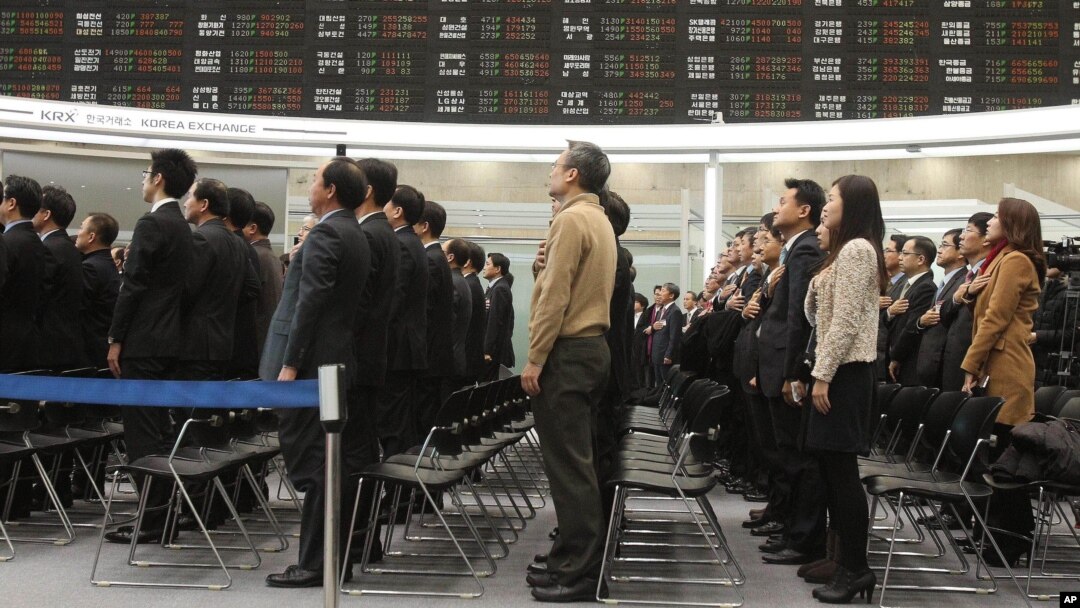韩国首尔证券交易所在2013年1月2日举行开市庆典,员工起立向国旗敬礼