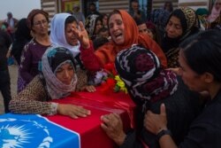 Women mourn at a funeral for a Kurdish-led government security guard on the outskirts of Tal Tamer, Syria, Oct. 21, 2019. (Yan Boechat/VOA)