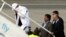 FILE - Lockerbie airline bomber Abdel Basset al-Megrahi, left, who was released from prison on compassionate grounds because he was terminally ill, boards an airplane accompanied by Libyan officials at Glasgow airport, Glasgow, Scotland, Aug. 20, 2009.