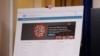 A poster displaying information from the White House Coronavirus Task Force is carried into the briefing room of the White House in Washington, Tuesday, March, 10, 2020, before Vice President Mike Pence and others arrive to speak. (AP Photo/Carolyn…