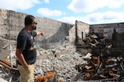 Ruhel Islam shows where the kitchen use to be in his restaurant. (K. Khan/VOA)