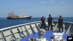 Ảnh của Cảnh sát biển Philippines ngày 27/4/2021: Nhân viên trên tàu tuần tra của Philippines theo dõi các tàu được cho là tàu của lực lượng dân quân Trung Quốc tại bãi cạn Sabina trên Biển Đông. 