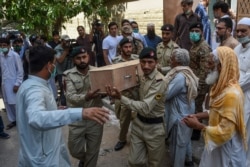 Army soldiers carry the coffin of a crash victim during a funeral a day after a Pakistan International Airlines aircraft crashed in a residential area in Karachi, Pakistan, May 23, 2020.