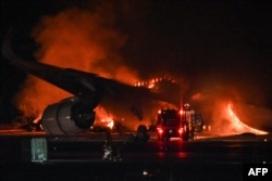 Sebuah pesawat penumpang Japan Airlines (JAL) terlihat terbakar di landasan Bandara Internasional Tokyo di Haneda pada 2 Januari 2024. (Foto: AFP)