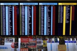 Protest placards are placed as the flights information board shows the cancellation of outbound flights at the Hong Kong International Airport, Aug. 12, 2019.