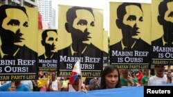 FILE - Protesters display placards with images of national revolutionary hero Apolinario Mabini as they march to the Chinese consulate office in Makati, Metro Manila, June 12, 2014.