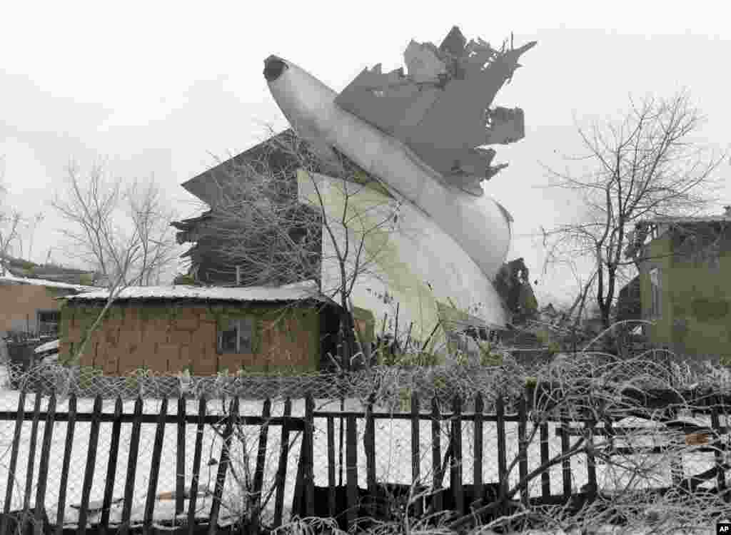 The tail of a crashed Turkish Boeing 747 cargo plane lies at a residential area outside Bishkek, Kyrgyzstan, killing at least 37 people in the residential area adjacent to the Manas airport as well as those on the plane.