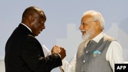 FILE - South African President Cyril Ramaphosa (L) and Prime Minister of India Narendra Modi (R) shake hands during the 2023 BRICS Summit at the Sandton Convention Centre in Johannesburg on August 24, 2023.