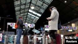 Travelers wait for a train at the Saint-Lazare railway station during a strike by all unions of French SNCF workers and the Paris transport network (RATP) as trade unions press on with a transport strike over the festive holidays in Paris, France,…