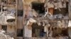 A man watches rescuers sift through the rubble as they search for people still missing at the site of Friday's Israeli strike in Beirut's southern suburbs, Lebanon, Sept. 23, 2024. 